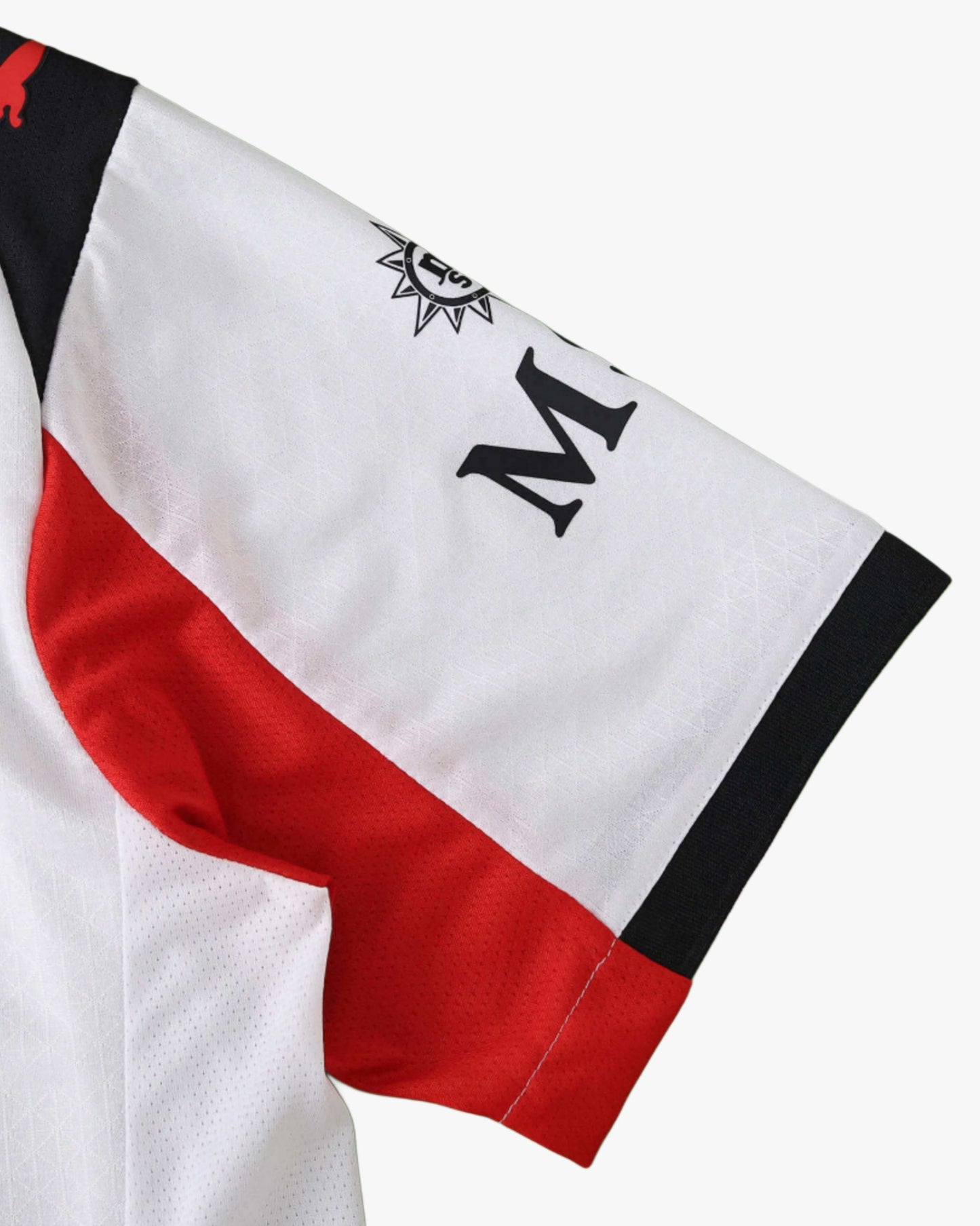 Close-up of the white, red, and black sleeve on the AC Milan 2025/26 away jersey.