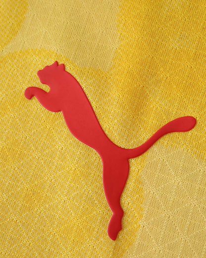 A red Puma logo is on a yellow textured fabric.