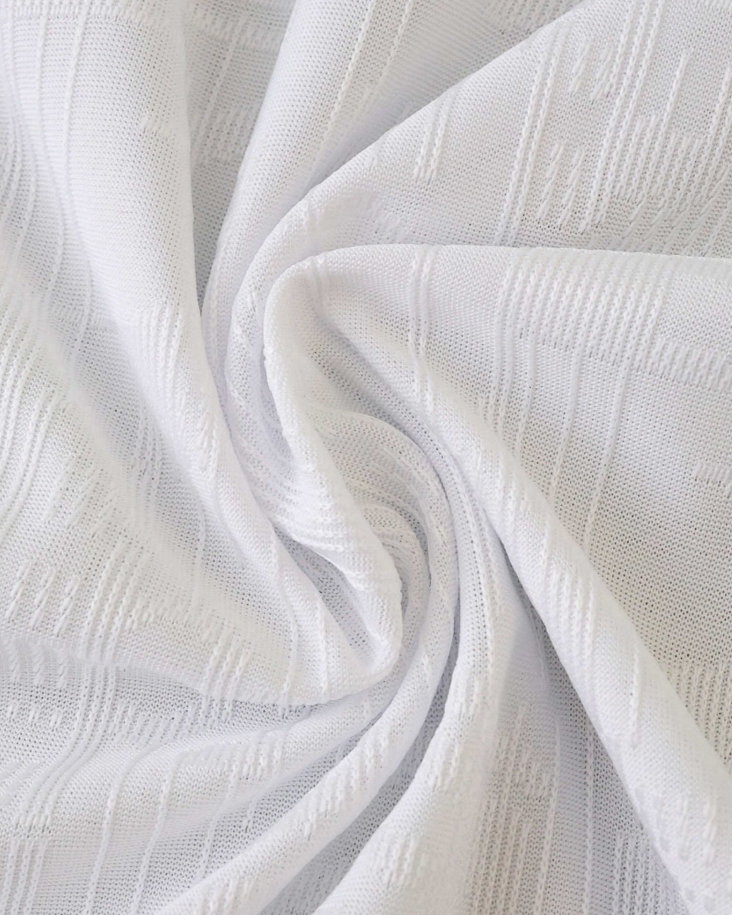 White textured fabric with a subtle geometric pattern.