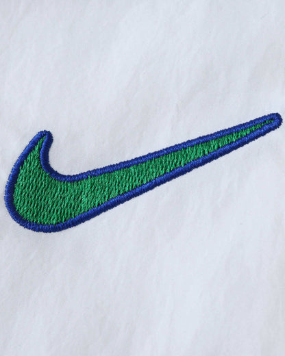 Embroidered green and blue Nike logo on a white background.
