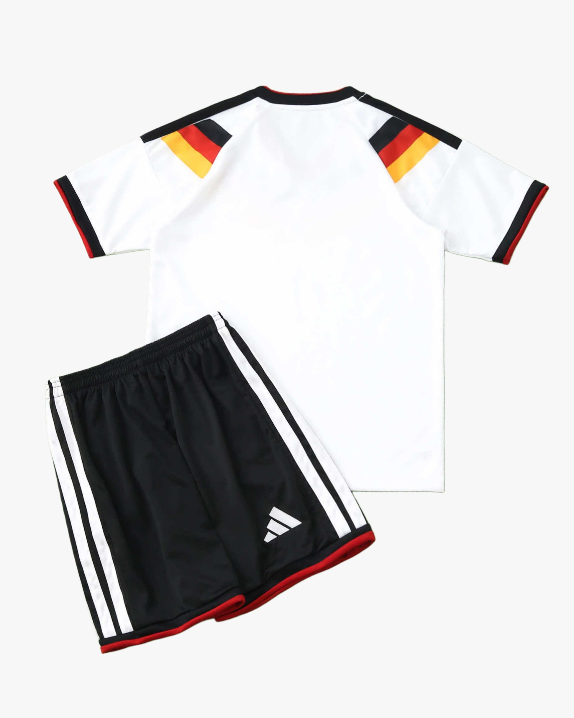 A white Germany home soccer jersey with black, red, and gold shoulder stripes and black shorts.
