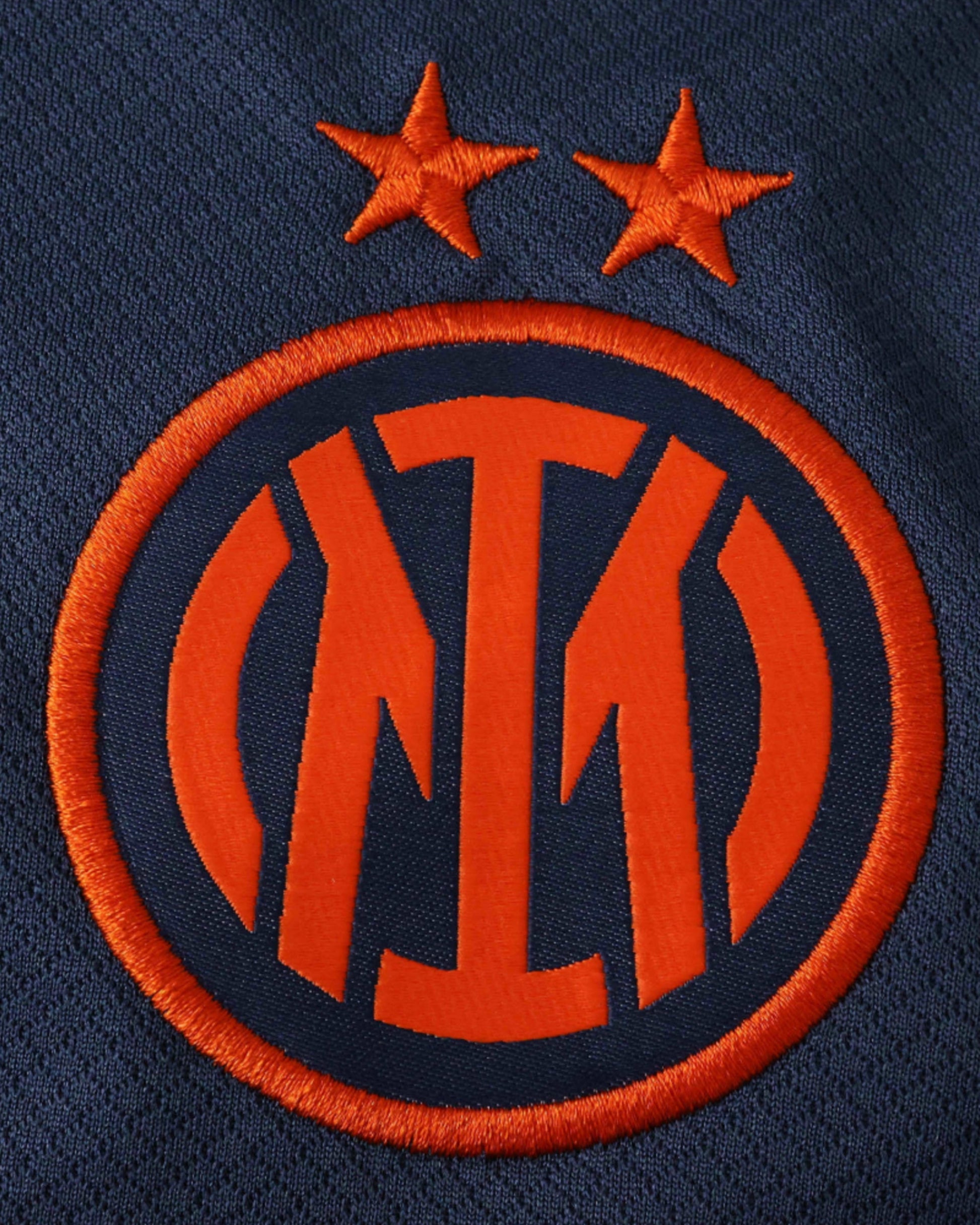 Inter Milan 2025/26 third kit logo with two orange stars above a circular emblem.