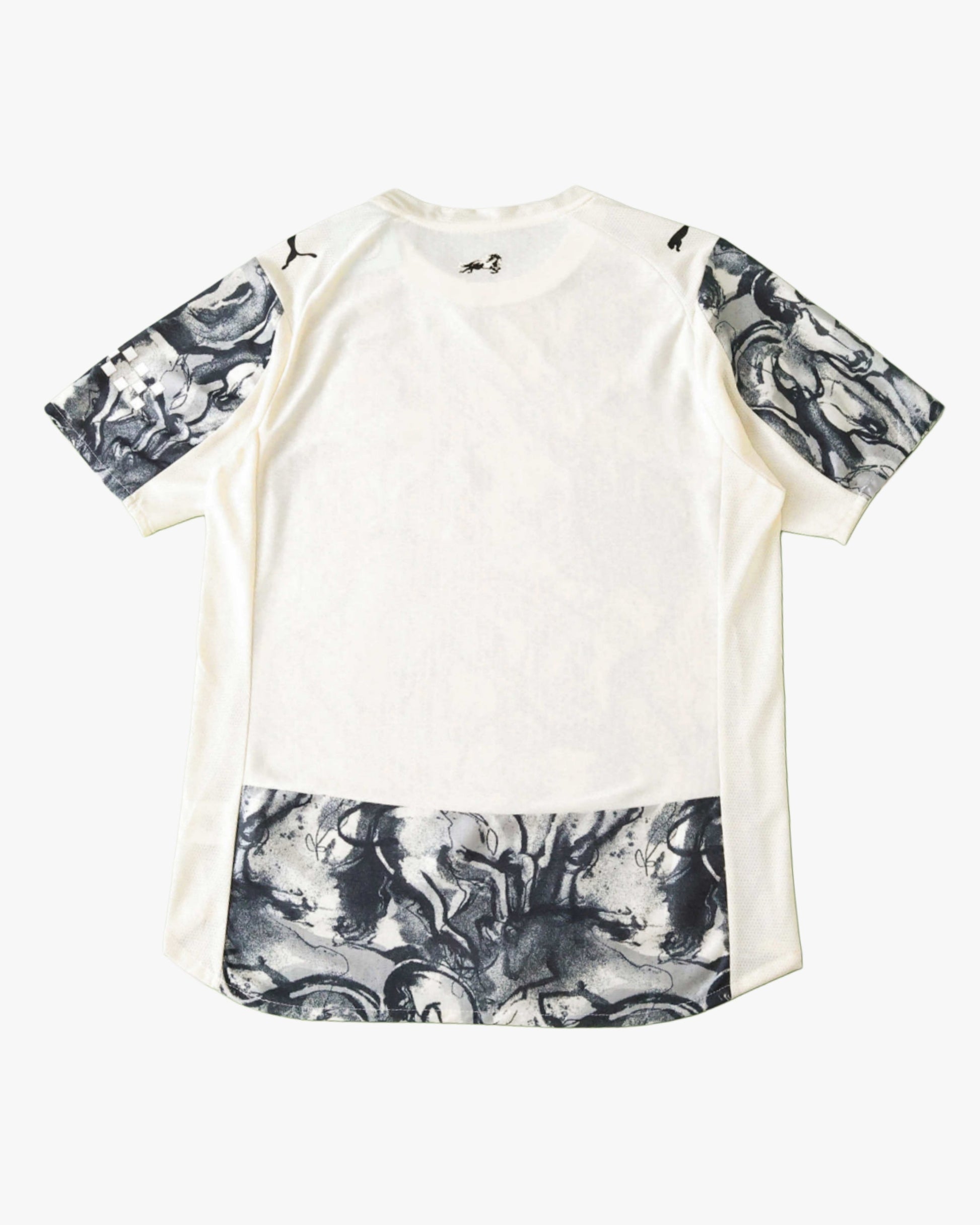 White Manchester City football jersey with horse graphic on sleeves and hem.