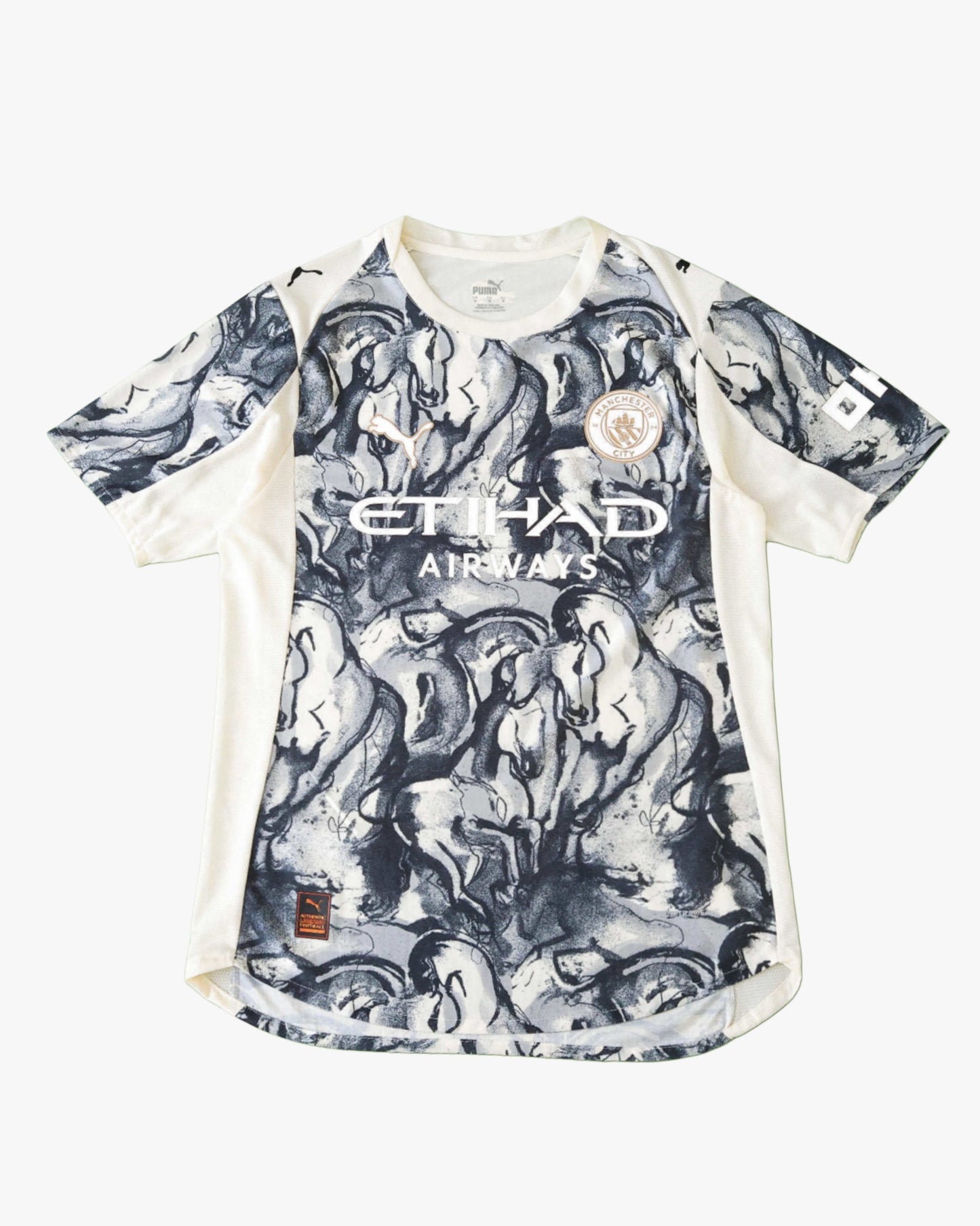 A blue Manchester City football jersey with a horse graphic print.