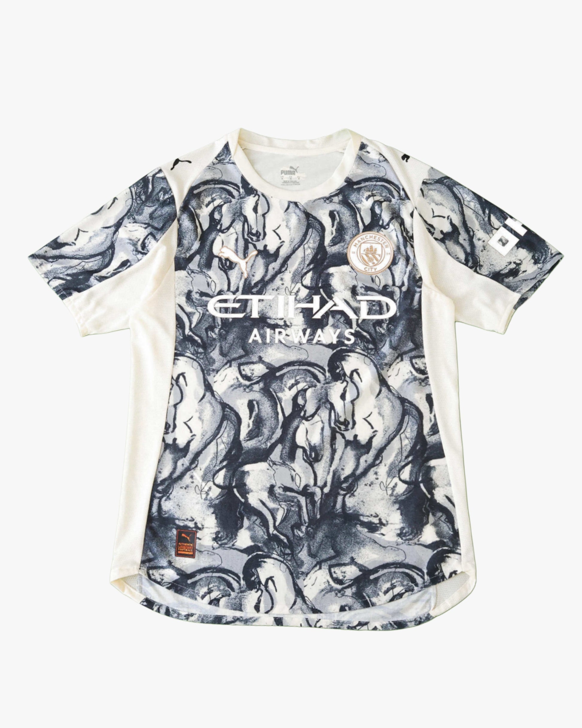 A blue Manchester City football jersey with a horse graphic print.