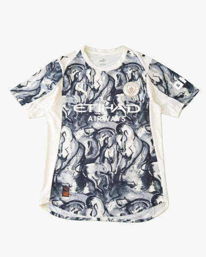 A blue Manchester City football jersey with a horse graphic print.
