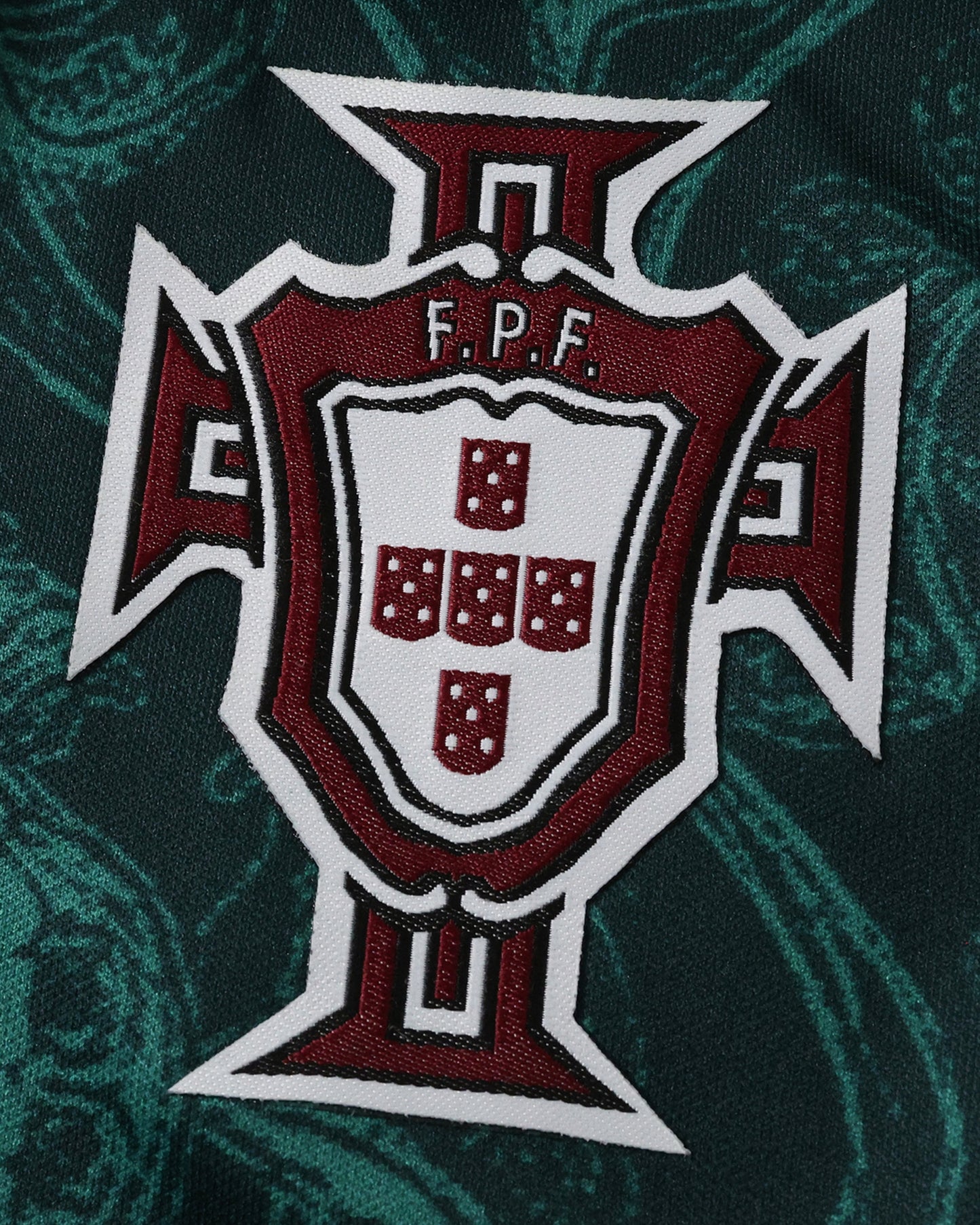 Portugal Forest Vine football jersey close-up of red and yellow FPF crest on green damask fabric