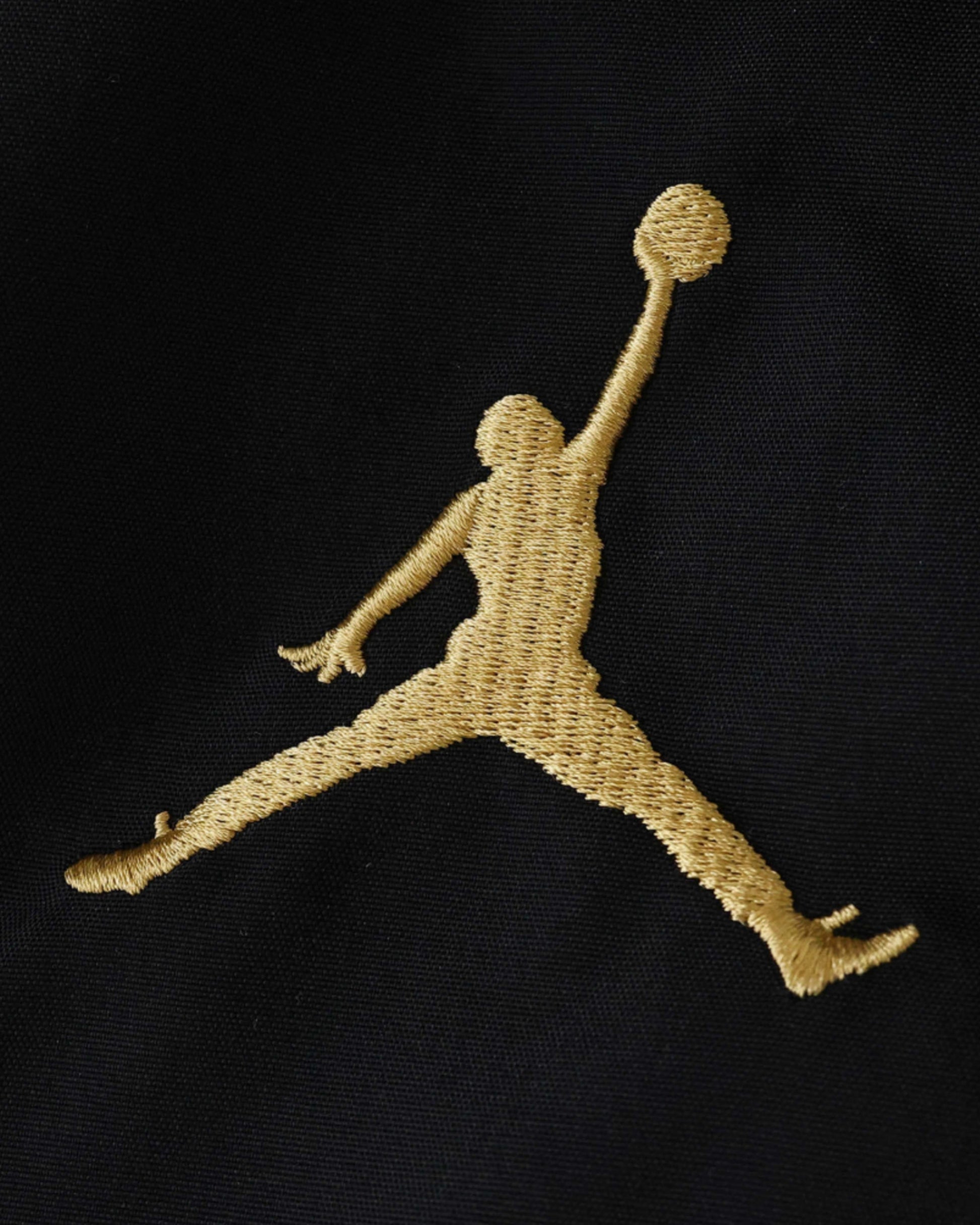 Gold Jordan Jumpman logo embroidered on a black fabric.