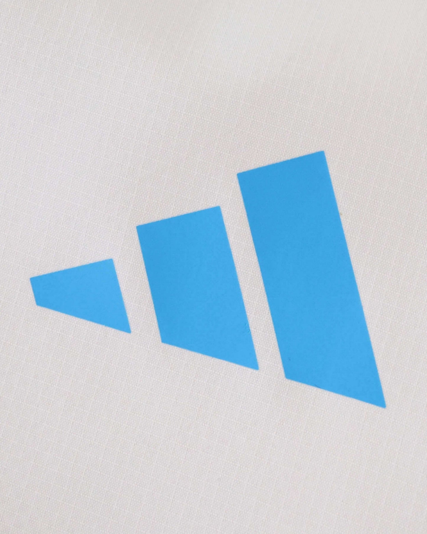 A white Real Madrid windbreaker with a blue three-bar logo.