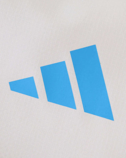 A white Real Madrid windbreaker with a blue three-bar logo.