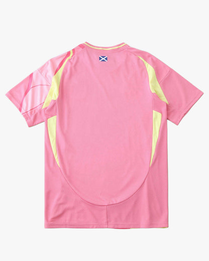 Pink Footxo Scotland away football shirt with yellow accents and a blue cross emblem.