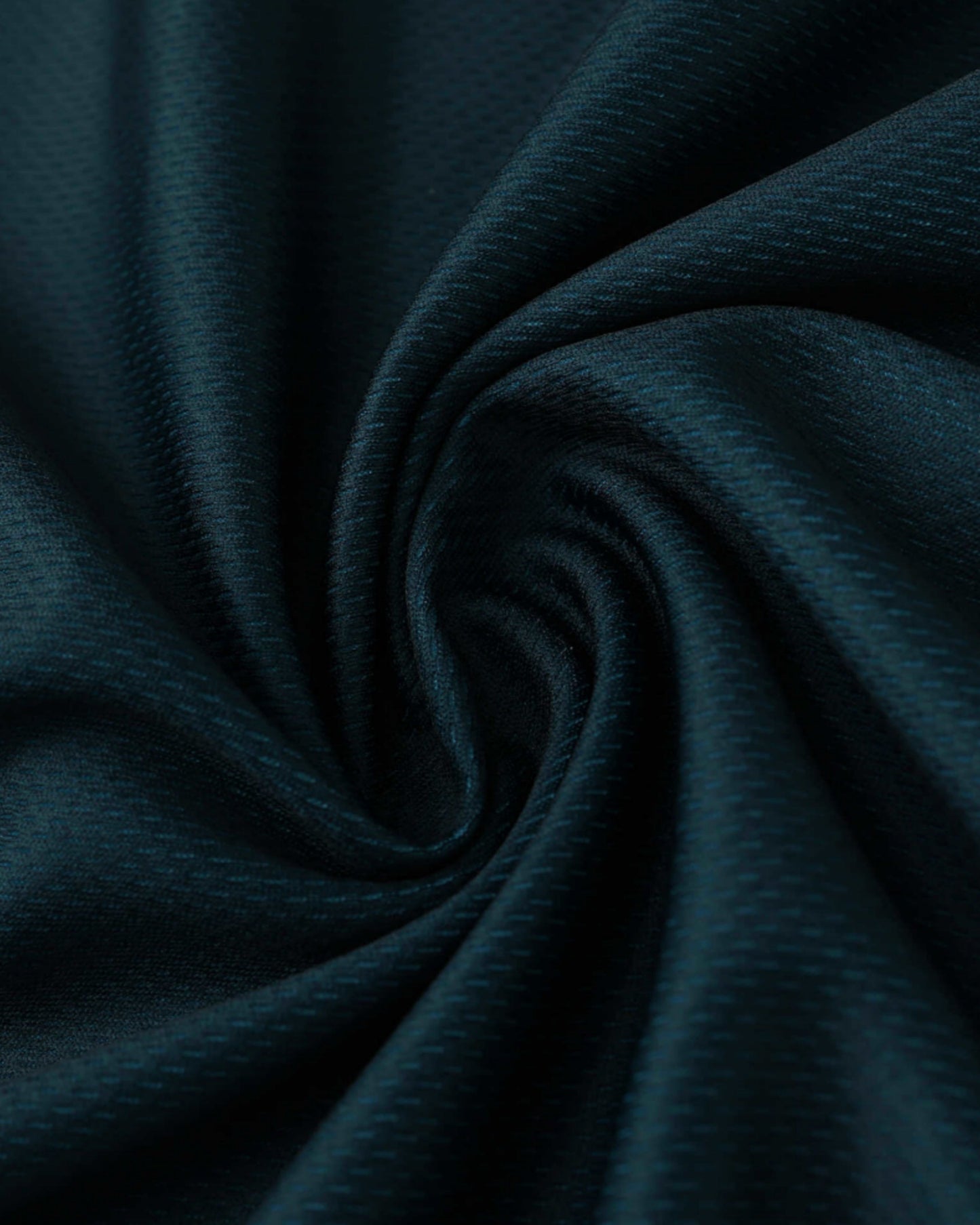 Dark teal fabric with a subtle textured pattern, swirled into a spiral.