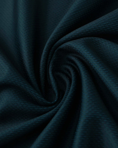Dark teal fabric with a subtle textured pattern, swirled into a spiral.